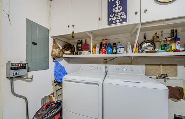 laundry room featuring cabinets, electric panel, and washing machine and clothes dryer