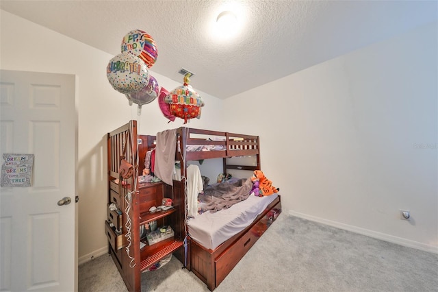 carpeted bedroom with a textured ceiling and vaulted ceiling