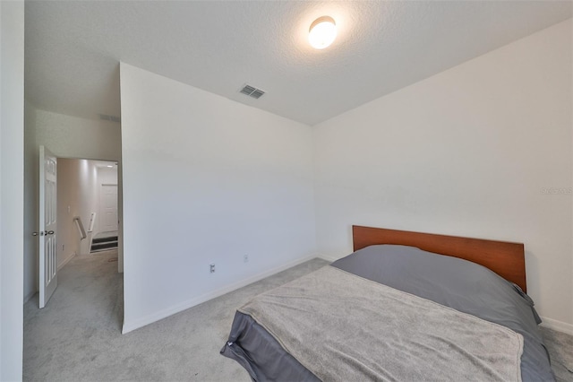 carpeted bedroom featuring a textured ceiling