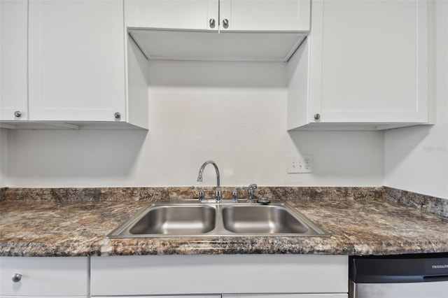 kitchen featuring stainless steel dishwasher, white cabinetry, and sink