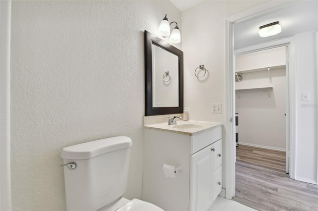 bathroom featuring vanity, hardwood / wood-style floors, and toilet