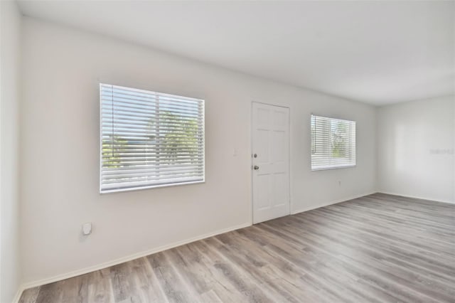 empty room featuring a healthy amount of sunlight and light hardwood / wood-style flooring