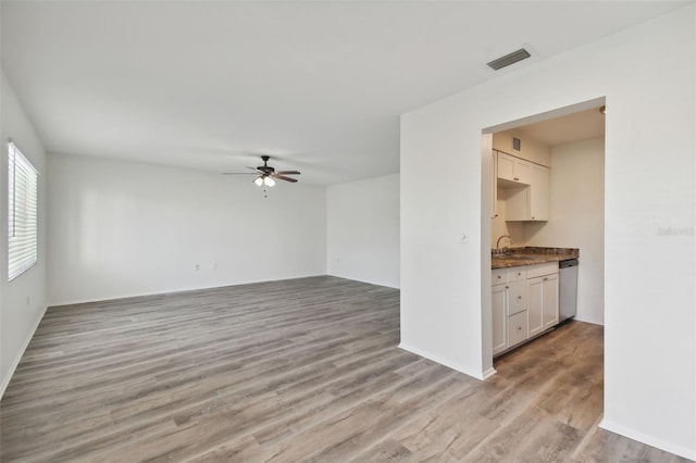 interior space with ceiling fan, light hardwood / wood-style flooring, and sink