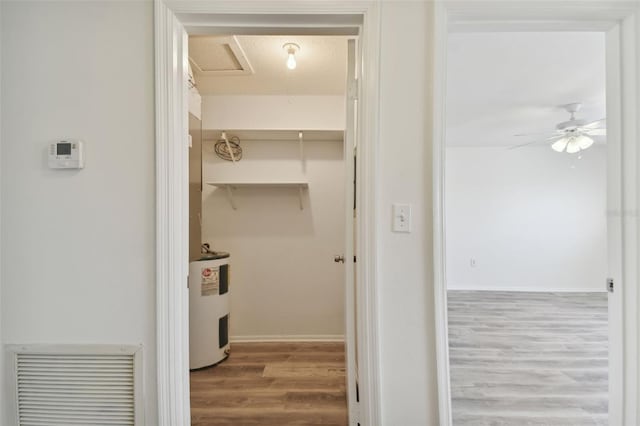 bathroom featuring ceiling fan, water heater, and hardwood / wood-style floors