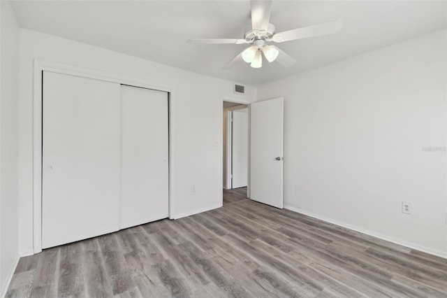 unfurnished bedroom with light hardwood / wood-style floors, a closet, and ceiling fan