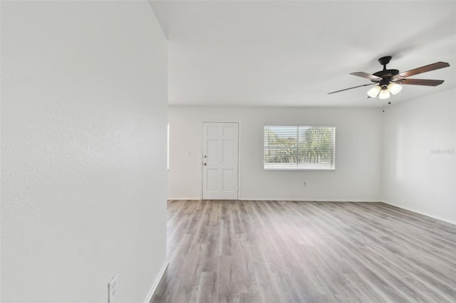 spare room with light wood-type flooring and ceiling fan