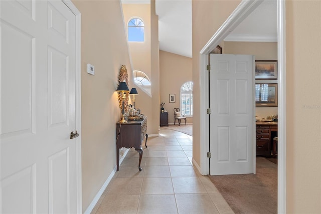 entryway featuring ornamental molding, vaulted ceiling, and light tile patterned flooring