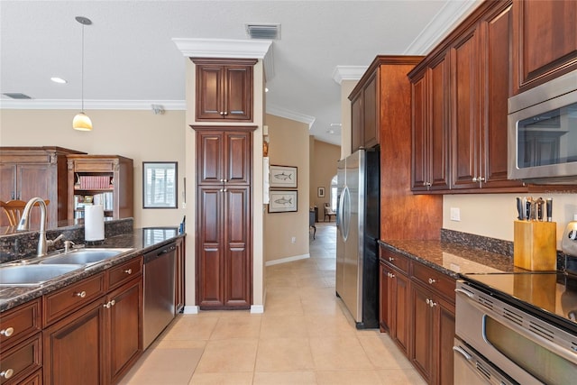 kitchen with dark stone countertops, appliances with stainless steel finishes, light tile patterned floors, and hanging light fixtures