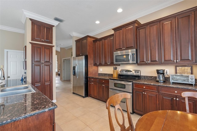 kitchen featuring light tile patterned floors, crown molding, stainless steel appliances, sink, and dark stone countertops