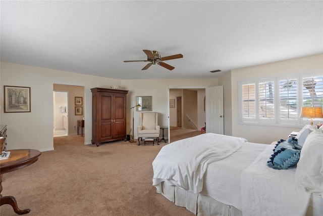 bedroom with light carpet, a textured ceiling, and ceiling fan