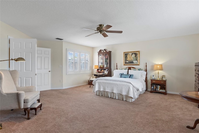 carpeted bedroom featuring a textured ceiling and ceiling fan