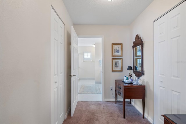 hall featuring a textured ceiling and carpet