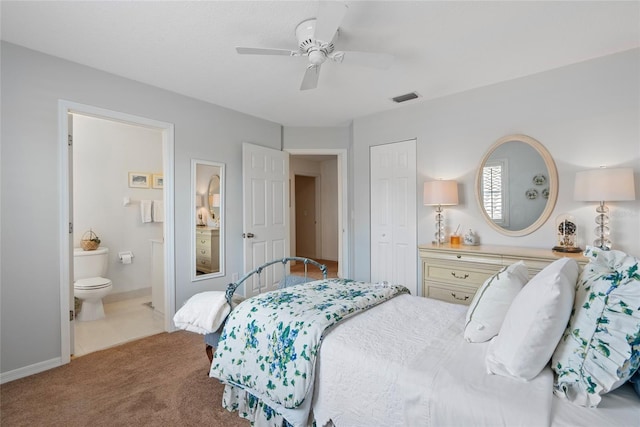 bedroom with light colored carpet, ceiling fan, a closet, and ensuite bath