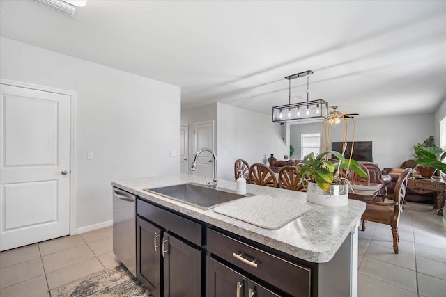 kitchen with dishwasher, an island with sink, hanging light fixtures, sink, and dark brown cabinetry