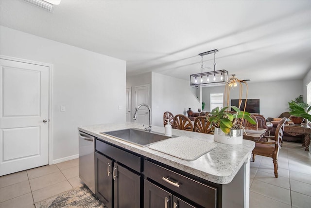 kitchen featuring light countertops, a sink, stainless steel dishwasher, open floor plan, and light tile patterned floors