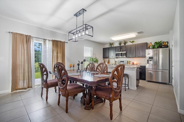 dining area featuring light tile patterned floors, plenty of natural light, and baseboards
