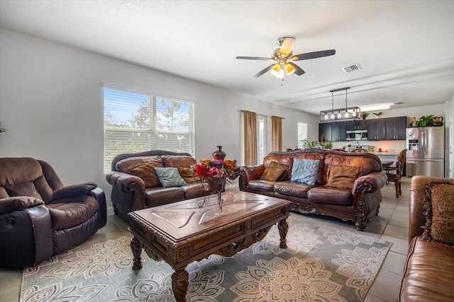 living room featuring light tile patterned floors, ceiling fan, and visible vents