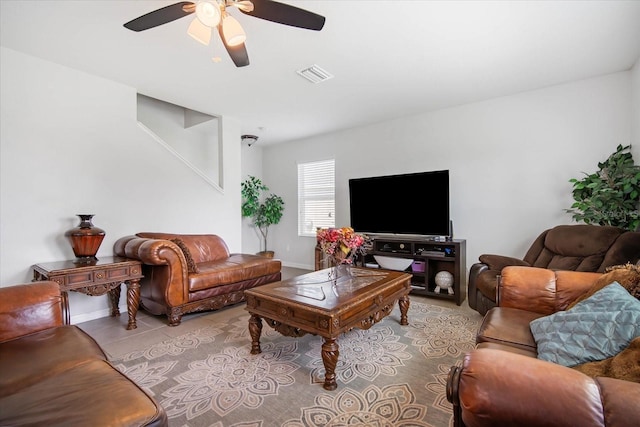 living room with light tile patterned flooring, baseboards, visible vents, and ceiling fan