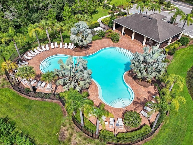 community pool with fence and a patio area