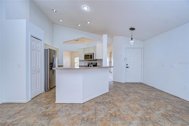 kitchen with lofted ceiling, pendant lighting, appliances with stainless steel finishes, and white cabinets