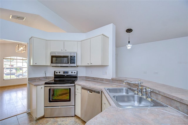 kitchen featuring sink, decorative light fixtures, stainless steel counters, and appliances with stainless steel finishes