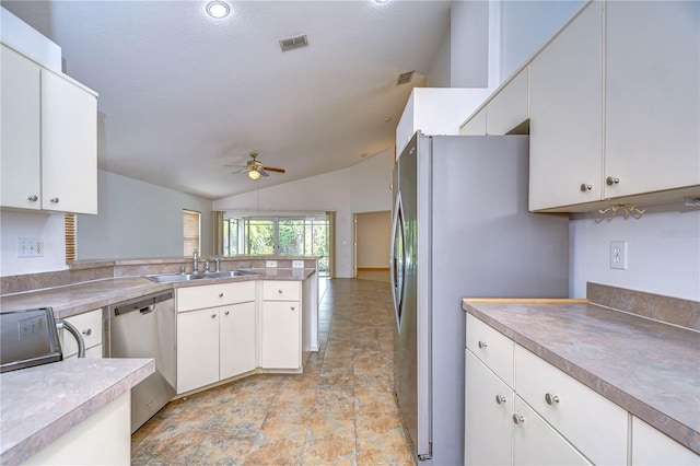 kitchen featuring vaulted ceiling, white cabinetry, appliances with stainless steel finishes, and sink