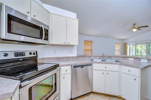 kitchen with lofted ceiling, sink, white cabinetry, appliances with stainless steel finishes, and ceiling fan