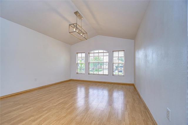 empty room featuring vaulted ceiling and light hardwood / wood-style floors