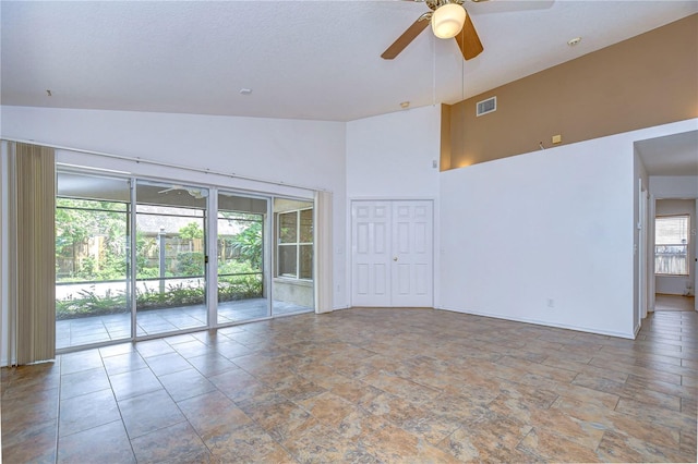 spare room featuring ceiling fan and a high ceiling