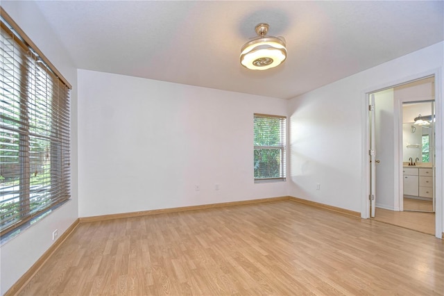 unfurnished room with sink and light hardwood / wood-style floors