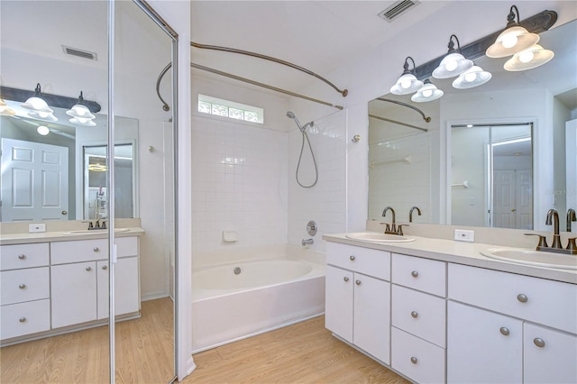 bathroom with wood-type flooring, bathtub / shower combination, and vanity