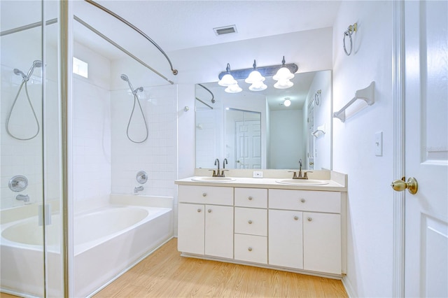 bathroom featuring vanity, hardwood / wood-style floors, and tiled shower / bath