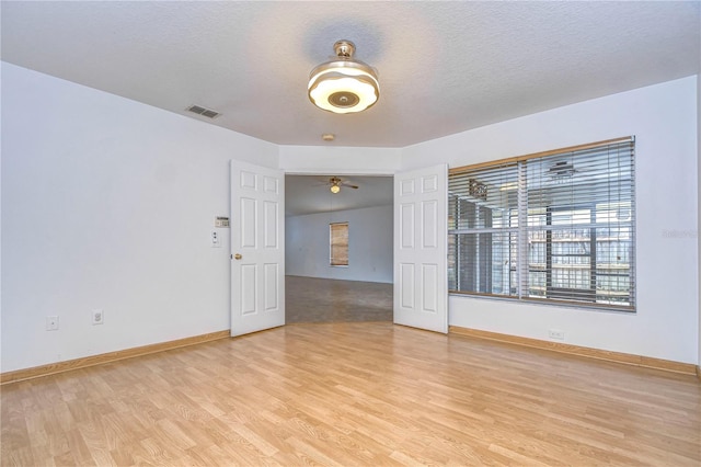 unfurnished room with a textured ceiling and light hardwood / wood-style flooring