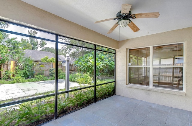 unfurnished sunroom with ceiling fan