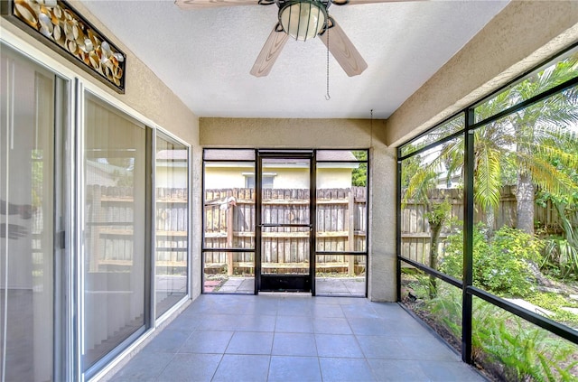 unfurnished sunroom featuring ceiling fan