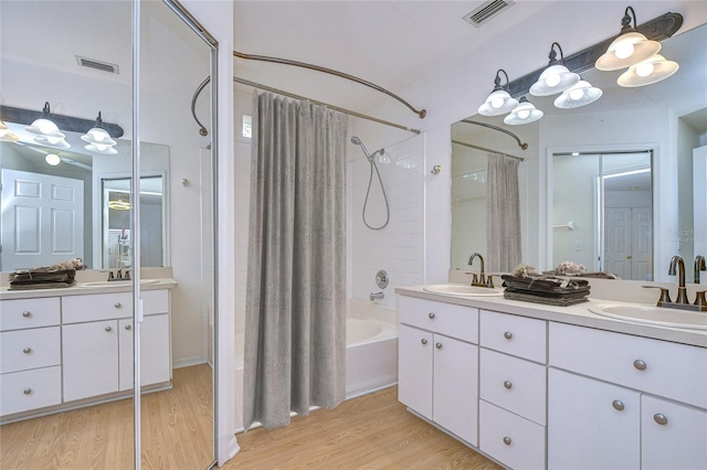 bathroom featuring hardwood / wood-style flooring, vanity, and shower / tub combo with curtain