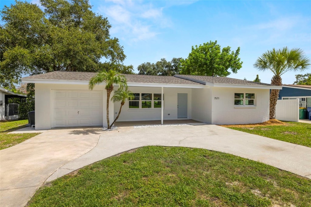 ranch-style house featuring a garage and a front lawn