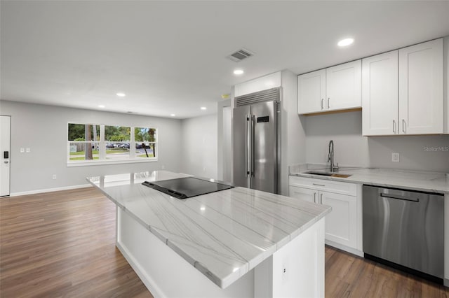 kitchen featuring a kitchen island, appliances with stainless steel finishes, sink, and white cabinetry