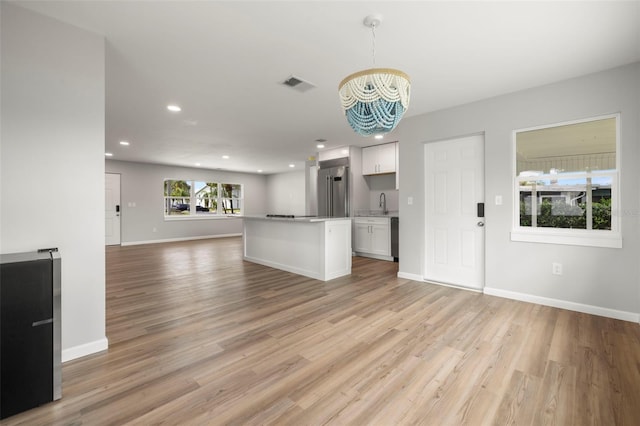 unfurnished living room with sink and light hardwood / wood-style floors