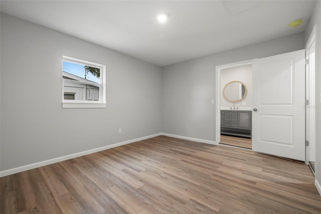 interior space with ensuite bath, light hardwood / wood-style floors, and sink