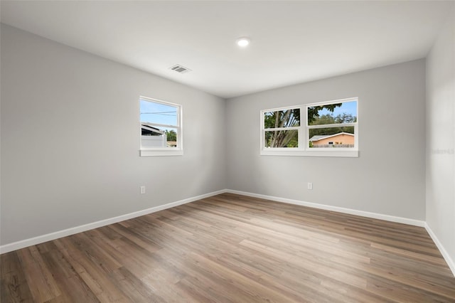 unfurnished room with plenty of natural light and hardwood / wood-style floors