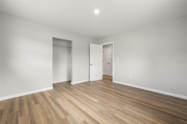 unfurnished bedroom with a closet and light hardwood / wood-style floors