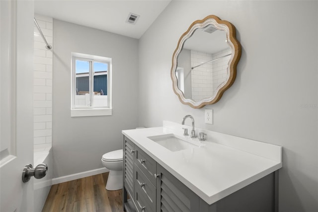 full bathroom featuring tiled shower / bath combo, hardwood / wood-style flooring, vanity, and toilet