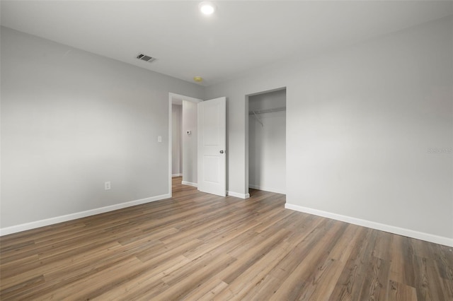 unfurnished bedroom featuring a closet and hardwood / wood-style floors