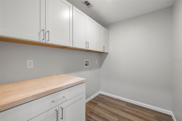 washroom with hookup for a washing machine, dark hardwood / wood-style flooring, and cabinets