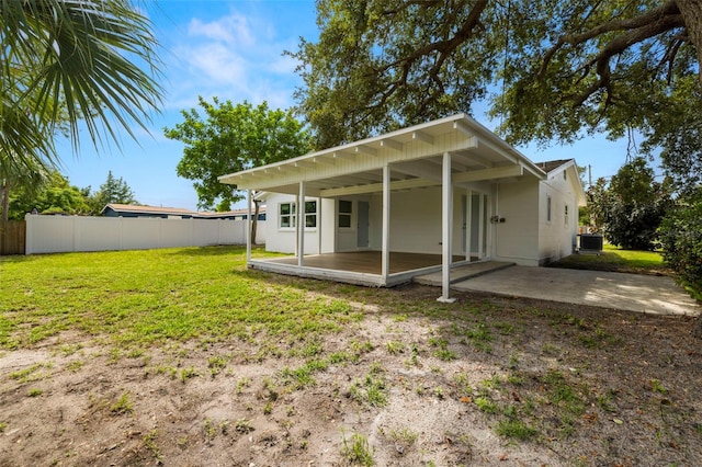 rear view of house with a lawn, a patio, and central AC unit