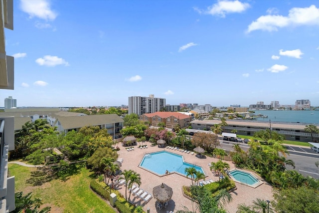 view of swimming pool featuring a patio and a water view