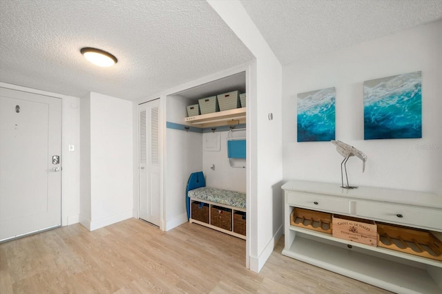 mudroom with a textured ceiling and light hardwood / wood-style floors