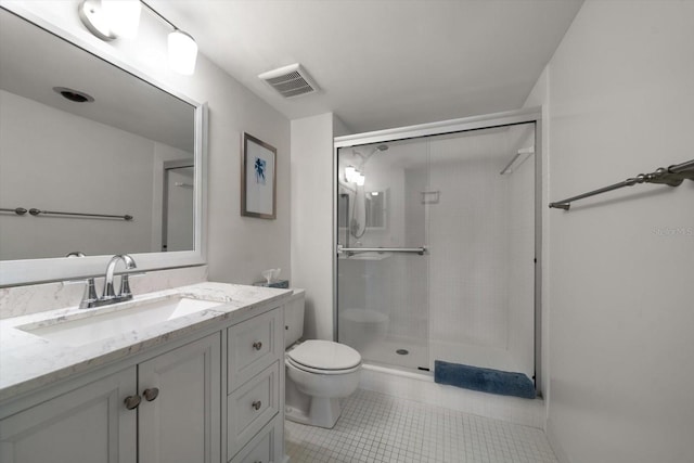 bathroom featuring tile patterned flooring, vanity, toilet, and a shower with door