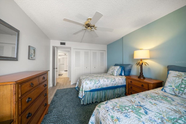 bedroom featuring ceiling fan, a closet, light hardwood / wood-style floors, and a textured ceiling